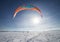 Kite boarders in snowy landscape