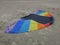 Kite in rainbowcolors with white threads laying on the beach of Velsen Netherlands