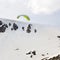 Kite skier flying off the mountain ridge