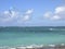 Kite surfer on blue water, with blue kite high in the air,