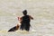 A kite surfer getting back on board after a fall