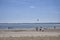 Kite Surfers, Kayakers and Holidaymakers enjoying the Sandy Beach of Beadnell Bay in Northumberland.