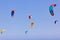 Kite-surfing against a beautiful blue sky. Many silhouettes of kites in the sky. Travel concept. Beauty world. watersports. Wind