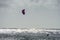 A kiteboarder or paraborder sails on the cornish waves. UK