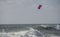 A kiteboarder or paraborder sails on the cornish waves. UK