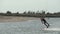 Kiteboarder rides on a kite in sea bay. Freestyle kiter training on pond kiteboarding spot. Kitesurfer enjoying ride