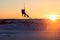 Kiteboarder sportsman under sunset sun, freestyle kiteboarding rider on the evening kitesession, sunset in the snow mountains,