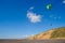 Kites fly over the coast in the blue sky