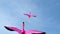 Kites of flying pink flamingo birds flying high in the air against blue sky