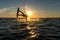 Kitesurfer doing handslide in sunset with sunstar and silhouette