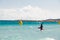 A kitesurfer gliding near the beach La Cinta, Sardinia