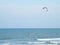 Kitesurfer riding kite on the beautiful blue sea with soft waves