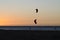 Kitesurfer silhouette at sunset riding