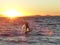 Kitesurfer surfs and jumps into sunset in Hyeres , France