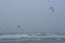 kitesurfers at sea suring a storm at a dutch beach