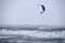 Kitesurfing, riding board waves during storm holding to flying kite