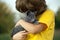 Kitten on arm of the boy outdoors, child huge his love pet