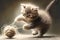 kitten chasing a ball of string, playfully biting and pawing at it