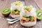 Kiwi, banana, coconut parfaits in mason jars on rustic wood