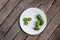 Kiwi berries (arctic kiwifruit) on white plate on wooden table