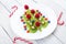 Kiwi christmas tree with raspberry, blueberry and cowberry on white wooden table with candy