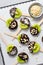 Kiwi Coved In Chocolate with Shredded Coconut and Nuts on a Stick, Healthy Snack on Bright Background