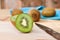 Kiwi fruit on chopping block brown wood background