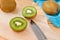 Kiwi fruit on chopping block brown wood background