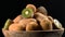 Kiwi in wooden bowl on black background