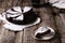 Kladdkaka. Traditional Swedish moist chocolate cake on old rustic wooden table decorated dry twigs, pine cones and birch bark