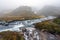 Klifbrekkufossar waterfall in the eastern part of Iceland during rainy and foggy weather.