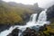 Klifbrekkufossar waterfall in the eastern part of Iceland during rainy and foggy weather.