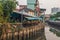 A klong or river channel with fishing boats, buildings and house fronts in Thailand