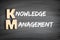 KM - Knowledge Management acronym, business concept on blackboard