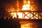 Kneeling firefighters in front of burning structure during firefighting exercise