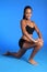 Kneeling hip flexor stretch by African woman