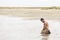 Kneeling Shirtless Soldier at the Sea Water