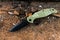 Knife with black blade and green handl. Old wood. Military.