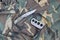 Knife and brass knuckles on a camouflage clothes background. Tools for self-defense or offender attacks