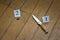 Knife and cartridge case on a brown wooden background, murder, robbery, evidence on the floor, investigation