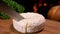 Knife carves a sector of French round cheese