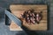 Knife and chopped sausage on a wooden chopping board. Food flat lay, top view. German traditional blutwurst in rustic style