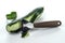 Knife for cleaning vegetables and fruits with cucumber with peeled skin.