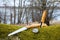 Knife, compass and saw on moss in the spring forest.