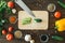 Knife, cucumbers paprika tomatoes and garlic lie on a wooden background