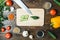 Knife, cucumbers paprika tomatoes and garlic lie on a wooden background