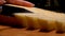 Knife cuts a hard parmesan cheese into thick slices