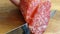 The knife cuts salami sausage