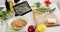 Knife, cutting board, vegetables and tablet on counter in sunny kitchen, slow motion