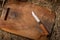 Knife and cutting board. Wooden cutting board on the hay. Rustic style